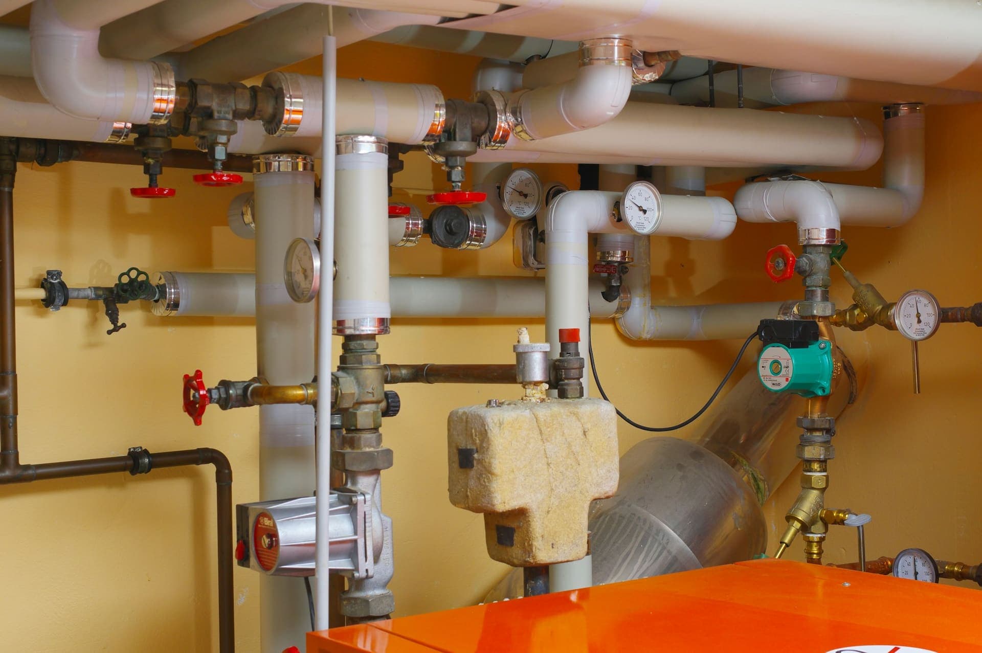 Cv-installatie met leidingen en kranen in een technische ruimte